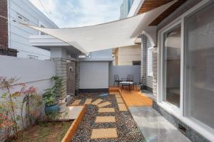 un patio con toldo en el lateral de una casa en Under the Tree, en Busan