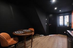 a black room with a table and two chairs at L'atypique Chez Les Amoureux in Le Touvet +12 photos