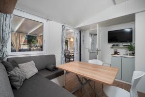 a living room with a couch and a table at NIKO Mobile Home in Biograd na Moru