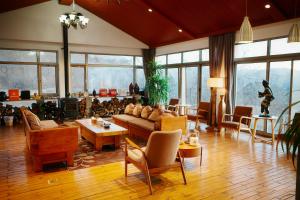 a living room with a couch and tables and chairs at 北京丛林里野奢汤泉酒店 in Huairou