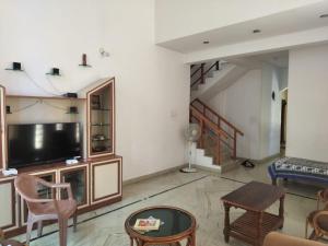 a living room with a flat screen tv and a couch at Serenity Springs in Mysore