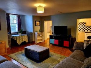 a living room with a couch and a tv at A Basement Apartment in Carmarthen
