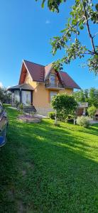 a house with a green lawn in front of it at Vikendica Sana in Sanski most