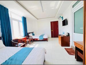 une chambre d'hôtel avec deux lits et une télévision à écran plat dans l'établissement Khách Sạn Phú Thành 1 Hotel Đà Lạt, à Đà Lạt