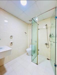 une salle de bain avec une douche en verre et des toilettes dans l'établissement Khách Sạn Phú Thành 1 Hotel Đà Lạt, à Đà Lạt