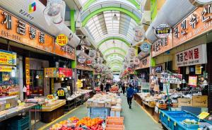 a market with people walking through a market with fruits and vegetables at Everville, Gaegeum Everville 304 #Stairs to 3rd floor in Busan