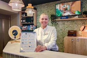 ニースにあるHôtel de France, un hôtel AMMIの店のカウンターに立っている男