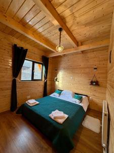 a bedroom with a bed in a wooden cabin at Cabana Apuseni Wild in Valea Lupşei +89 photos