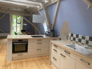eine Küche mit weißen Schränken und einem Herd mit Backofen in der Unterkunft Grosse Galeriewohnung mit Sauna "Fondels Mühle" in Boppard