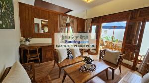 Una sala de estar con mesa y sillas y una cocina. en Jepara Garden Resort, en Jepara