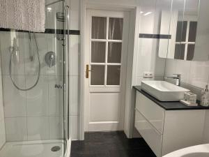 ein weißes Badezimmer mit Dusche und Waschbecken in der Unterkunft Grosse Galeriewohnung mit Sauna "Fondels Mühle" in Boppard + 27 Fotos
