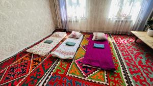 a bedroom with two beds and a rug on the floor at Nurislam GuestHouse in At-Bashy
