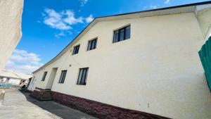 a white building with windows on the side of it at Nurislam GuestHouse in At-Bashy