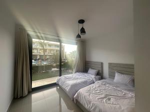 two twin beds in a bedroom with a window at G Cribs Hotel Apartment 2BR in Hurghada