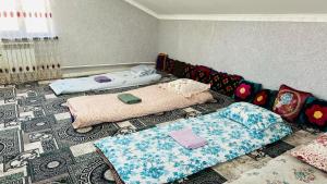 a living room with two beds and a couch at Nurislam GuestHouse in At-Bashy
