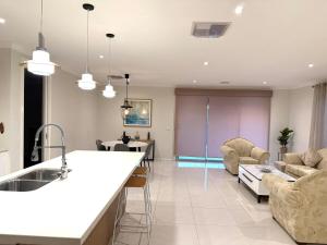 克莱基伯恩Home in Craigieburn的厨房以及带水槽和沙发的客厅。