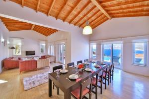 a dining room with a table and chairs in a living room at Villa Basil in Kaş
