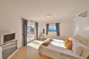 a white room with a bed and a television at Villa Basil in Kaş +23 photos