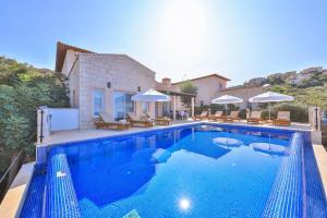 a large blue swimming pool in front of a house at Villa Basil in Kaş