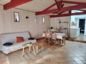 a living room with a bed and a table at Les Gîtes C&H in Les Herbiers
