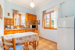 una cocina con una mesa y un refrigerador en Dolce Far Niente, en Kato Korakiana