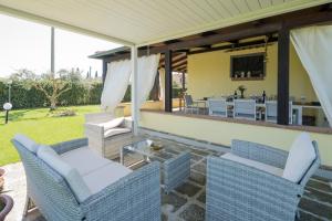 a patio with two chairs and a table with a dining room at Casale Fattoria Benaris With Private Pool - Marsiliana in Marsiliana