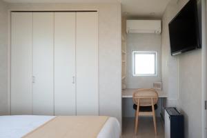 石垣島にある"オーシャンビュー ヴィラ南十字星 " Two-Bedroom Villaのベッドと机と椅子のある寝室