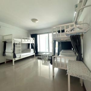 ein Zimmer mit zwei Etagenbetten und einem Fenster in der Unterkunft 소다호스텔 Soda Hostel in Chiang Mai