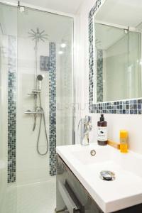 een badkamer met wastafel en douche met spiegel bij Les Moraes By Silastur in Cudillero