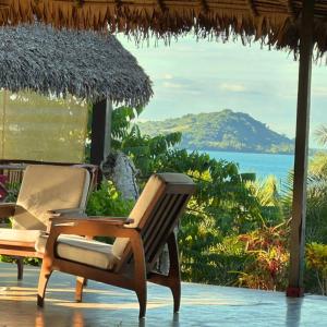 a pair of chairs on a patio with a view of the ocean at WINGS HOTELS in Nosy Be +59 photos