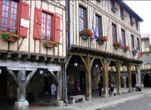 an old building with red shutters on a street at Maison de charme à Bélesta in Bélesta
