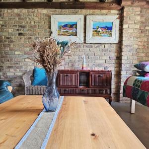 a living room with a table and a brick wall at Villa Dachie in Rayton +4 photos