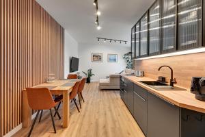 a kitchen with a wooden table and a dining room at Comfort Apartments Botanika in Gdańsk