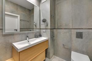 a bathroom with a sink and a mirror at Comfort Apartments Botanika in Gdańsk +16 photos