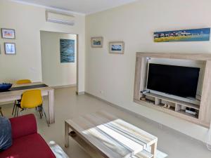 a living room with a large flat screen tv at Royal Cabanas Golf by Amandio Batista in Cabanas de Tavira