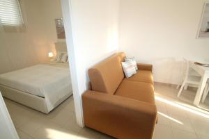 un soggiorno con un divano e un letto di Giada a Baia Verde