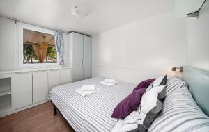 a small bedroom with a bed and a window at NIKO Mobile Home in Biograd na Moru