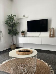 a living room with a tv on a white wall at Dimi Guest House in Perea