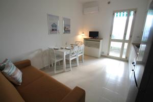 un soggiorno con un divano e un tavolo di Giada a Baia Verde