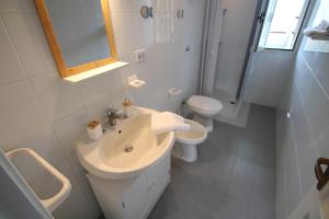 un bagno bianco con lavandino e WC di Giada a Baia Verde Altre 17 foto