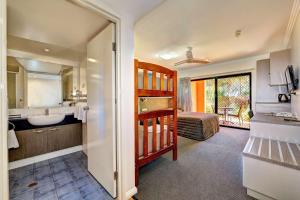 a bathroom with a sink and a large mirror at Kacy's Bargara Beach Motel in Bargara