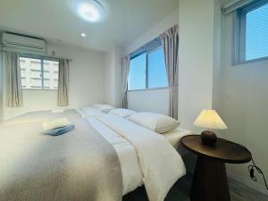 ein Schlafzimmer mit 2 Betten und einer Lampe auf einem Tisch in der Unterkunft LOFT-Hatsudai hostel初台SY0362 in Tokio