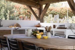 a dining room table with chairs and a wooden table at La Grange de Fer - Maison de caractère piscine privée in Saint-Ferréol-Trente-Pas