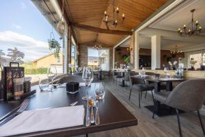 a restaurant with wooden ceilings and tables and chairs at Fletcher Hotel Restaurant Bon Repos in Noorbeek