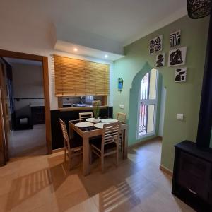 a kitchen and dining room with a table and chairs at Casita a 200 metros de la playa con acceso a todo in Málaga