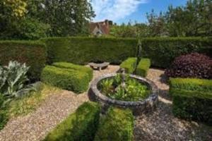 a garden with hedges and a bench in the middle at Old Manor House, an idyllic country house in Shabbington +33 photos