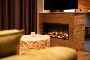 a fireplace in a living room with a table in front of it at Arven slow living apartments - Ledro in Tiarno di Sotto