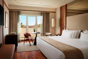 a hotel room with a large bed and a table at NH Collection Marbella in Marbella