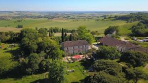 an aerial view of a mansion in a field at Lodge Crusoé aux Nuits Insolites d'Argoumbat in Beaumont-de-Lomagne