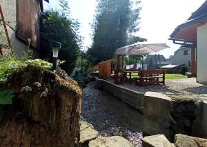 a garden with a bench and a table with an umbrella at Agroturystyka Pod Małą Górą in Łopuszna +71 photos